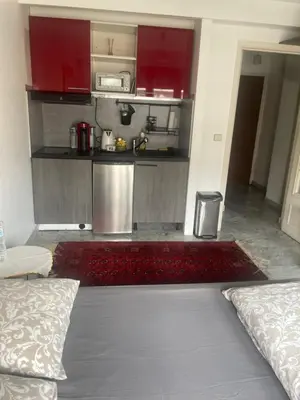 a small kitchen with red cabinets in a room at Studio 112 in Nice