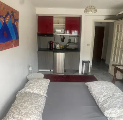 a bedroom with a large bed and a kitchen at Studio 112 in Nice