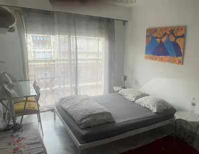 a bedroom with a bed with a window and a chair at Studio 112 in Nice