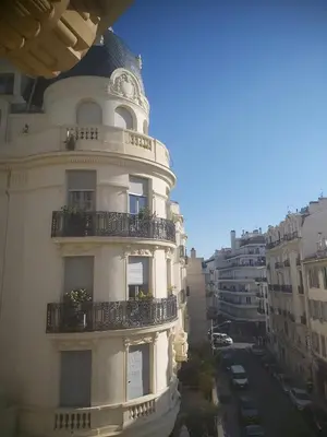 a white building with a balcony on a city street at Palais Clemenceau in Nice