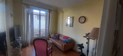 a living room with a couch and a clock on the wall at Palais Clemenceau in Nice