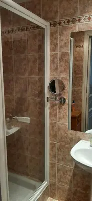 a shower with a glass door next to a sink at Palais Clemenceau in Nice