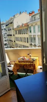 a table on a balcony with a view of a city at Palais Clemenceau in Nice