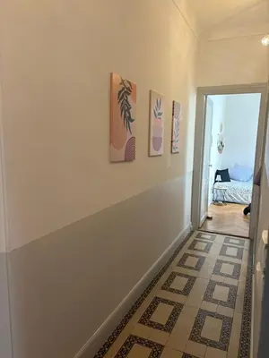 a hallway with three paintings on the wall and a doorway at Studio spacieux - Centre de Nice, proche mer & gare in Nice