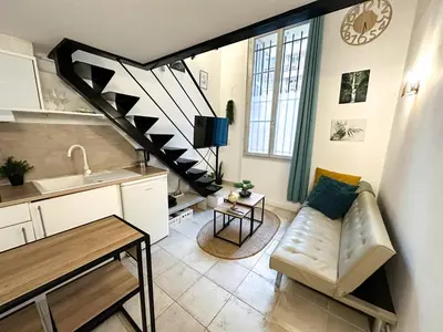 a living room with a couch and a staircase at AngeVert HolidayHouse in Nice