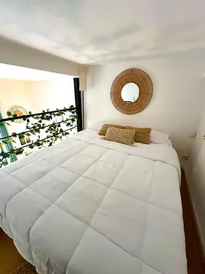 a large white bed in a bedroom with a window at AngeVert HolidayHouse in Nice