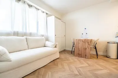a living room with a white couch and a table at L'Escale Niçoise in Nice