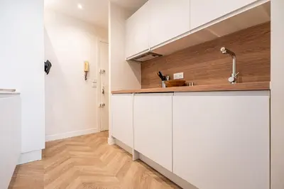 a kitchen with white cabinets and a sink at L'Escale Niçoise in Nice