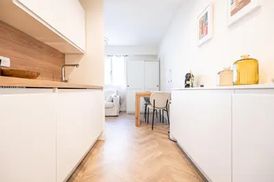a kitchen and dining room with white cabinets and a table at L'Escale Niçoise in Nice