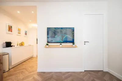 a room with a white wall with a painting at L'Escale Niçoise in Nice