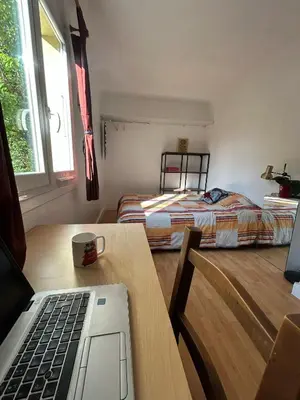a bedroom with a white bed and a desk at Cosy appartement en plein centre-ville dans un halo de verdure avec vue mer in Nice