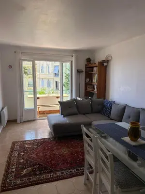 a bedroom with a bed and a laptop on a desk at Cosy appartement en plein centre-ville dans un halo de verdure avec vue mer in Nice