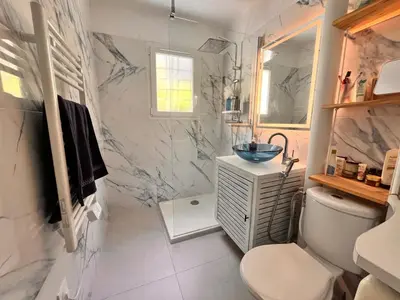 a bedroom with a bed with a colorful quilt on it at Cosy appartement en plein centre-ville dans un halo de verdure avec vue mer in Nice