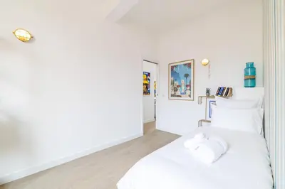 a white bedroom with a white bed with white pillows at Sunlight Properties - Archibald - Nice Port area, 2 Bedrooms, stunning holiday rental apartment with balcony & parking in Nice