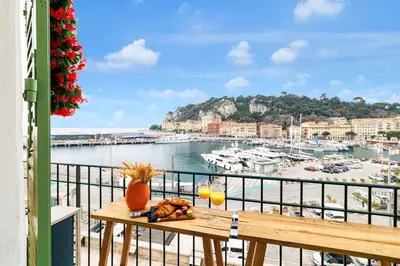 a table on a balcony with a view of a harbor at Sunlight Properties - Archibald - Nice Port area, 2 Bedrooms, stunning holiday rental apartment with balcony & parking in Nice