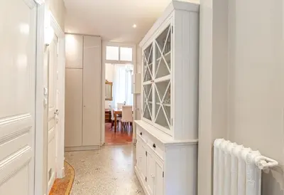 a kitchen with white cabinets and a dining room at Suite Bottero in Nice