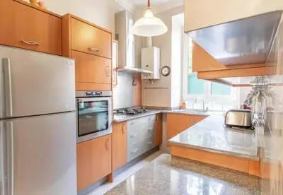 a kitchen with wooden cabinets and a white refrigerator at Suite Bottero in Nice