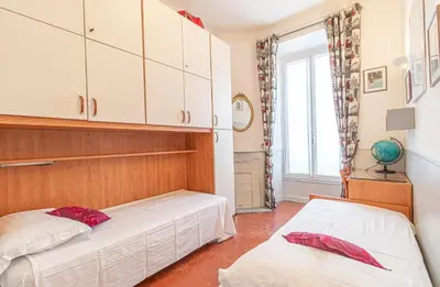 a bedroom with two beds and a window at Suite Bottero in Nice