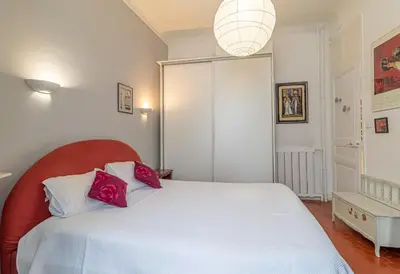 a bedroom with a white bed with red pillows at Suite Bottero in Nice