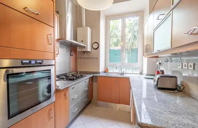 a kitchen with wooden cabinets and stainless steel appliances at Suite Bottero in Nice