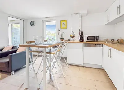 a kitchen and living room with a table and chairs at Havre de paix avec terrasse in La Gaude