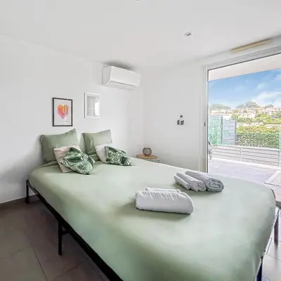 a bedroom with a large green bed with a window at Havre de paix avec terrasse in La Gaude