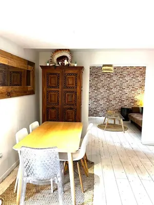 a dining room with a wooden table and chairs at Le Bohème 3 pièces jardin in Saint-Laurent-du-Var