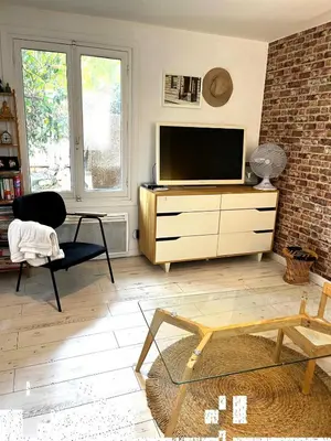 a living room with a television on a dresser at Le Bohème 3 pièces jardin in Saint-Laurent-du-Var