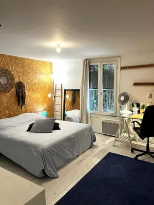 a bedroom with a bed and a desk and a window at Le Bohème 3 pièces jardin in Saint-Laurent-du-Var