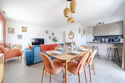 a dining room and living room with a table and chairs at Maison niçoise vue dégagée avec jacuzzi privatif in Nice