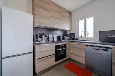 a kitchen with wooden cabinets and a dishwasher at Maison niçoise vue dégagée avec jacuzzi privatif in Nice