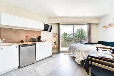 a kitchen and a bedroom with a bed and a window at Sandaya - 10min à pied de la Plage in Cagnes-sur-Mer