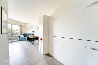 a kitchen with a refrigerator and a table at Sandaya - 10min à pied de la Plage in Cagnes-sur-Mer