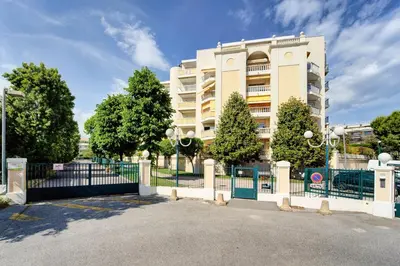 a white building with a fence in front of it at Sandaya - 10min à pied de la Plage in Cagnes-sur-Mer