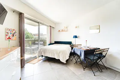 a bedroom with a bed and a desk with a table at Sandaya - 10min à pied de la Plage in Cagnes-sur-Mer