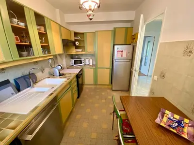 a kitchen with a table and a refrigerator at Nice West Pretty one bedroom in Nice