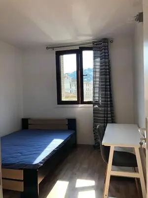 a bedroom with a bed and a desk and a window at Big Apartement 20 min from beach in Nice