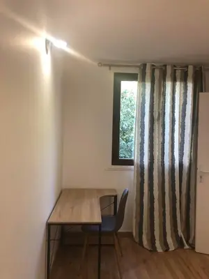 a table and a chair in a room with a window at Big Apartement 20 min from beach in Nice