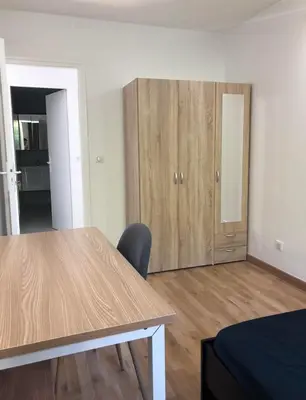 a room with a table and a wooden cabinet at Big Apartement 20 min from beach in Nice