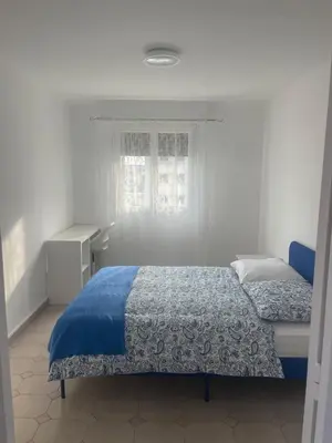 a bedroom with a blue bed and a window at Sun appart in Nice