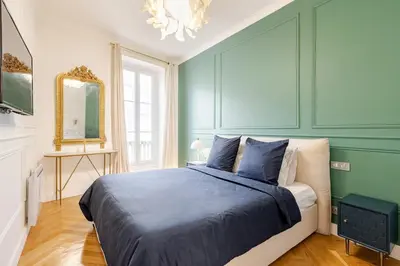 a bedroom with green walls and a bed with blue sheets at Bella Nissa Bnb - AC wifi - cosy - 2 bedrooms in Nice