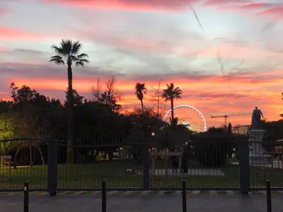 a sunset with a ferris wheel and palm trees at Bella Nissa Bnb - AC wifi - cosy - 2 bedrooms in Nice