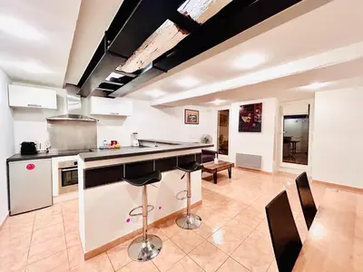 a kitchen with a counter and chairs in a room at Riviera Mornings - Old Town Stay - 5 Min to Beach & Breakfast in Villefranche-sur-Mer