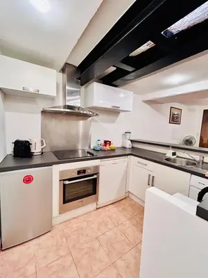 a kitchen with white cabinets and a stove top oven at Riviera Mornings - Old Town Stay - 5 Min to Beach & Breakfast in Villefranche-sur-Mer