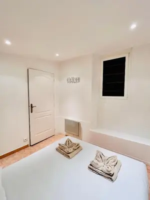 a white bedroom with a bed with towels on it at Riviera Mornings - Old Town Stay - 5 Min to Beach & Breakfast in Villefranche-sur-Mer