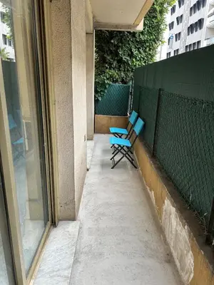 a blue chair sitting on a porch next to a fence at Deux pièces au centre-ville proche des plages et centres commerciaux in Saint-Laurent-du-Var