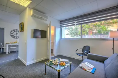 a living room with a couch and a table at Castel du Port - Happy Rentals in Saint-Laurent-du-Var
