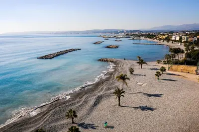 an aerial view of a beach with palm trees at Castel du Port - Happy Rentals in Saint-Laurent-du-Var