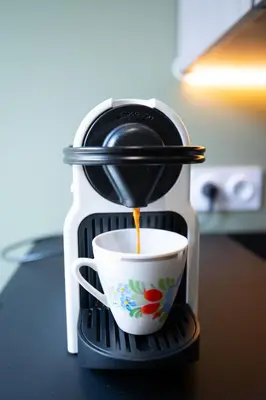 a coffee maker is pouring coffee into a cup at Spacieux et Moderne T2 - Hyper Centre in Nice