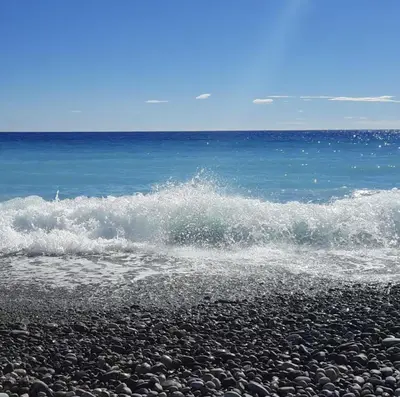 a wave crashing on a rocky beach in the ocean at Spacieux et Moderne T2 - Hyper Centre in Nice